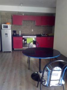 een keuken met rode kasten en een tafel en stoelen bij Departamento centrico San Juan de Dios in Guadalajara