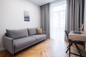 un soggiorno con divano e scrivania di 2BD,Terrace, AC, next to Dineika Park, Brand NEW, by Cohost a Druskininkai