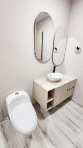 uma casa de banho com um WC, um lavatório e um espelho. em Casa Hotel Hefziba em Barranquilla