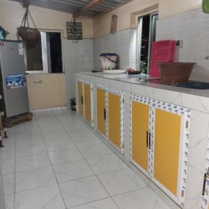 a kitchen with yellow and white cabinets at NAFI'0 in Gorée