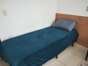 Una cama en una habitación con una manta azul. en Casa das Embaúbas 1 en São José