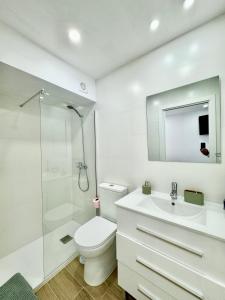 a white bathroom with a toilet and a shower at Amazing Seaside Studio by EaW Homes in Marbella