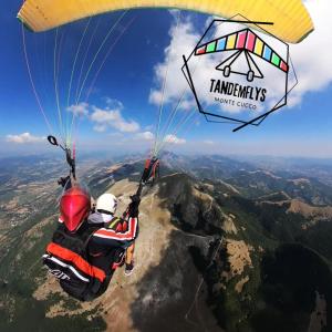 dos personas volando en paracaídas sobre una montaña en Albergo Ristorante Montecucco da Tobia en Sigillo