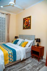 a bedroom with a bed and a table with a nightstand at F.A.M Homes Tabata in Dar es Salaam