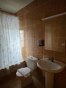 a bathroom with a toilet and a sink at Hostal El Corzo in Villafranca