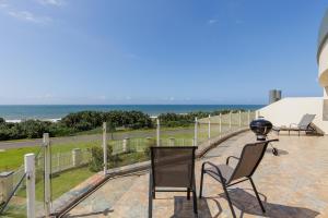 a patio with chairs and a lamp on top of a building at Uvongo Breeze 9 in Uvongo Beach