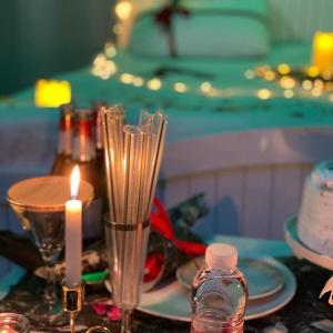 a table with a candle and a plate with at منتجع سمايل in Al Qurayyat