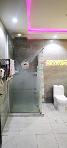 a bathroom with a glass shower with a toilet at منتجع سمايل in Al Qurayyat