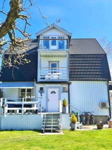 a white house with a white door and a building at Apartment in private villa in Gryta