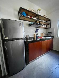 a kitchen with a stainless steel refrigerator and a counter at Suites Maya Ka’an in Cancún