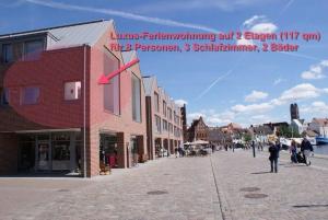 une rue avec un bâtiment avec un rouge x dessus dans l'établissement Hafenpanorama - ABC173, à Wismar