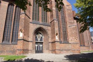 une grande église en briques avec une grande porte dans l'établissement Hafenpanorama - ABC173, à Wismar