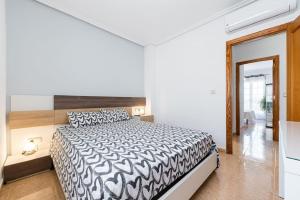 - une chambre avec un lit et une couette noire et blanche dans l'établissement Casa en Ciudad Quesada, à Ciudad Quesada