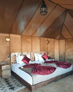 um quarto com 2 camas numa tenda em Sahara Safari Camp em Merzouga