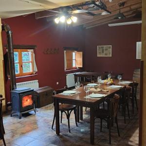 una sala da pranzo con tavolo e stufa a legna di El Jardin de la Huerta a Sahagún