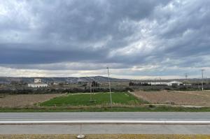an empty road with a field and a cloudy sky at Hostal El Corzo in Villafranca