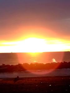a sunset on the beach with the sun setting at Sweet Home FCO Airport Roma in Fiumicino +33 photos