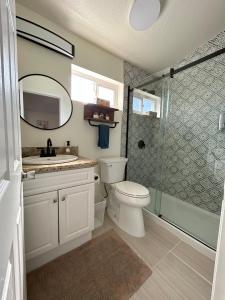 a bathroom with a toilet and a sink and a shower at Oceanside Getaway in Oceanside