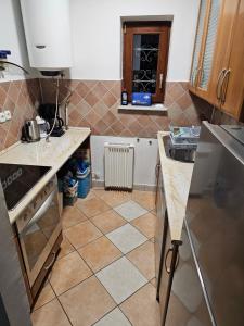 a kitchen with a sink and a tiled floor at Traumhaftes Ferienhaus im Buchengebirge in Bükkszentkereszt