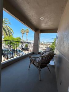 a balcony with a chair and a view of the beach at Oceanside Getaway in Oceanside