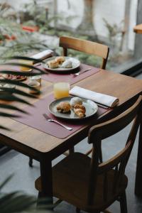 a wooden table with plates of food and a glass of orange juice at NINE DOTS Azorean Art Boutique Hotel in Ponta Delgada