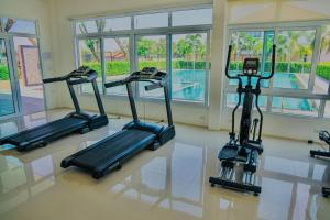 a gym with three treadmills in front of a pool at Luxury Entire House short term rent In Buriram City for SongKran Festival in Buriram