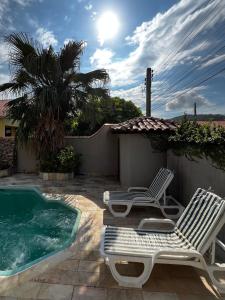 納維根特斯的住宿－Pousada Casa Chico，两把草坪椅和一个游泳池