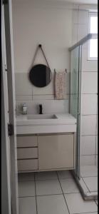 a white bathroom with a sink and a mirror at Apto para até 4 pessoas,ótima localização, área de lazer para crianças,conveniência e piscina in Petrolina