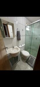 a bathroom with a toilet and a sink and a shower at Casa Inteira com Churrasqueira in Ponta Grossa