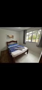 1 dormitorio con cama y ventana en Casa Inteira com Churrasqueira, en Ponta Grossa