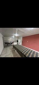 uma sala vazia com bancos e uma parede vermelha em Casa Inteira com Churrasqueira em Ponta Grossa
