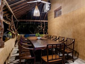 a dining room with a wooden table and chairs at Joe's Bungalow Yala in Kirinda