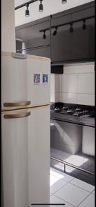 a kitchen with a white refrigerator and a stove at Apto para até 4 pessoas,ótima localização, área de lazer para crianças,conveniência e piscina in Petrolina