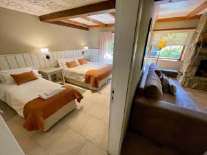 a bedroom with two beds and a couch in it at Las Marianas Hotel in San Carlos de Bariloche