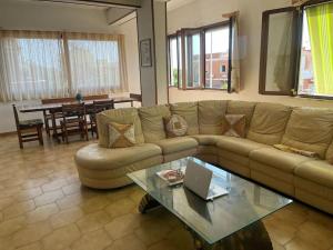 ein Wohnzimmer mit einem Sofa und einem Tisch mit einem Laptop in der Unterkunft Appartamento vista mare. in Campo Iemini