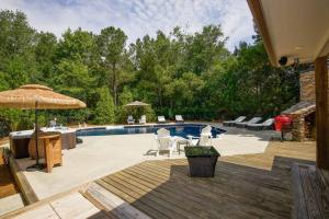 una piscina con sillas y sombrilla en Golf home Outdoor pool, Pool Table, Game room, Sleep up to 12, en Pinehurst