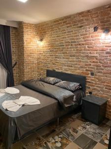 a bed in a room with a brick wall at Tüyap Fair Elit Home in Istanbul
