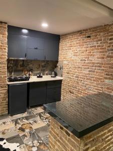 a kitchen with a counter and a brick wall at Tüyap Fair Elit Home in Istanbul