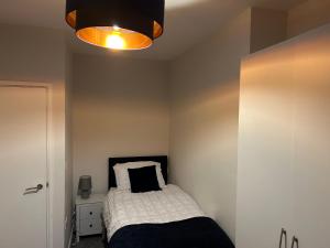 Dormitorio pequeño con cama y luz en Modern 2 bedroom apartment - Neath Town centre, en Neath