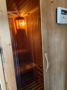 una sauna de madera con puerta de cristal en una cabaña en Picos Pardos CRA-AV-1088, en El Barraco