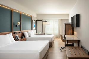 a hotel room with two beds and a desk at Courtyard by Marriott Lima Miraflores in Lima