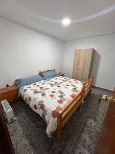 ein Schlafzimmer mit einem Bett mit einer Decke darauf in der Unterkunft Lovely rooms near the metro in Paterna