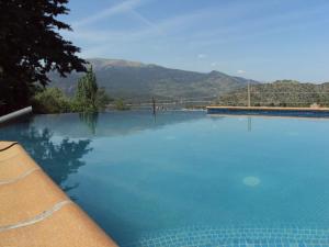 une grande piscine bleue avec des montagnes en arrière-plan dans l'établissement Picos Pardos CRA-AV-1088, à El Barraco