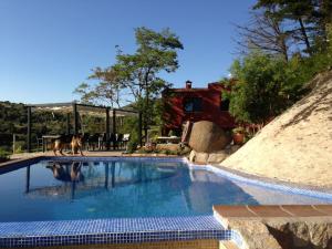 a dog walking by a swimming pool with a house at Casa rural en El Burguillo - Picos Pardos CRA-AV-1088 in El Barraco