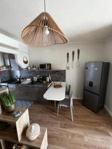 eine Küche mit einem weißen Tisch und einem schwarzen Kühlschrank in der Unterkunft Casa Marana in Borgo