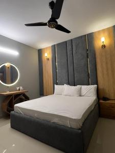 a bedroom with a bed with a ceiling fan at Marigold Accommodations in Karachi +4 photos