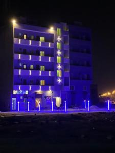 Marigold Accommodations في كراتشي: مبنى أمامه أضواء زرقاء في الليل