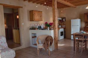 a kitchen and dining room with a table and a kitchen with a refrigerator at La Grange Du Haut in Saint-Antoine