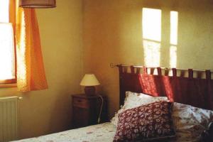 a bedroom with a bed and a lamp and a window at La Grange Du Haut in Saint-Antoine