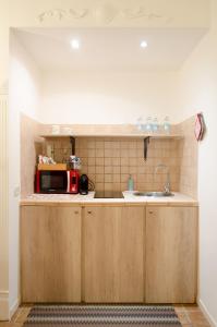 a kitchen with a sink and a microwave at Downtown Lodge Museum in Taranto